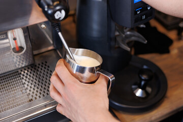 Close-up of espresso pouring from coffee machine. Professional coffee brewing.