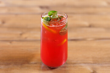 A fresh summer cocktail of strawberries, lime and mint with ice cubes.