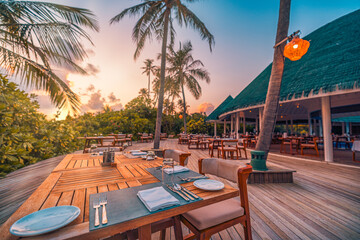 Outdoor restaurant at the beach. Table setting at tropical beach restaurant. Led light candles and...