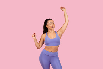 Joyful woman dancing in sports outfit, feeling free