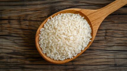 Fototapeta na wymiar Rice pile in wooden spoon isolated on wood table background.