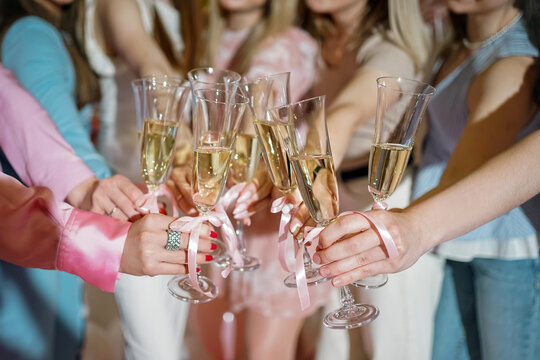 A group of girls celebrate a cheers at a bachelorette party with glasses of wine. Preparation for the wedding.