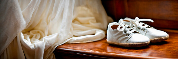 baby booties and a cross for baptism. Selective focus.