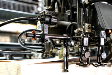 Fototapeta na wymiar Offset printing machine feeder transfer metallic paper through the feeding table to the printing unit