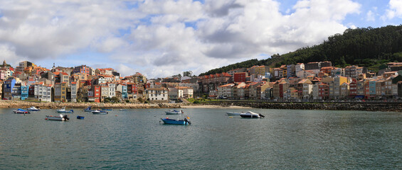 View of two sides of the town of La Guardia (A Guarda), in front of the port with boats in the sea. Galicia. Spain