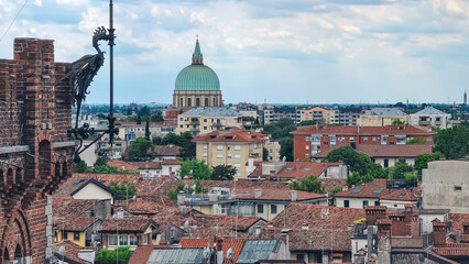 Fototapeta na wymiar Aerial panoramic view of historic city of Udine, Friuli Venezia Giulia, Italy, Europe. Viewing platform form castle of Udine. Dark clouds on overcast day. Classical Italian architecture red roofs