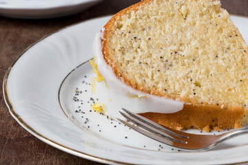 Detail of a Carrot Cake with Lemon Twist for Birthday Celebration, topped with delicate white icing and adorned with lemon zest decoration, The cake is elegantly presented, evoking joy