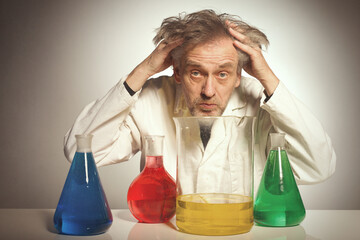 Older crazy chemist preparing a chemical experiment with some liquids