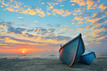 Sunrise at Black Sea over an old fishing boats - 729337951