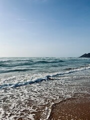 Fototapeta na wymiar Seashore background, sea horizon, sea foam at the sandy coast