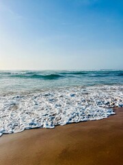 Seashore background, sea horizon, sea foam at the sandy coast