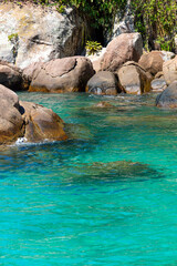 Fototapeta premium Abstract image of the contrast between the turquoise water and the rocks of Praia do Aventureiro, a tropical paradise in Ilha Grande, Angra dos Reis, Rio de Janeiro, Brazil.