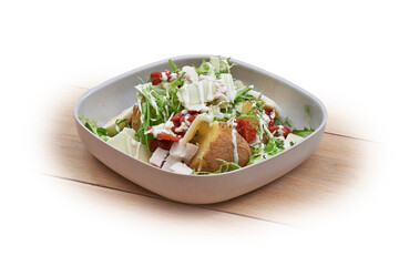 Bowl with hot patatoes, salad and caesar on white and wood