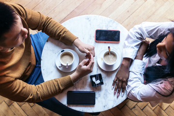 Overhead shot of two people on a date drinking coffee