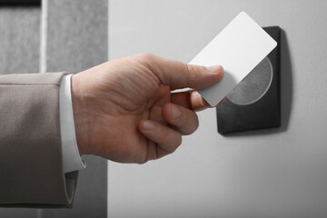 Man opening magnetic door lock with key card, closeup. Home security