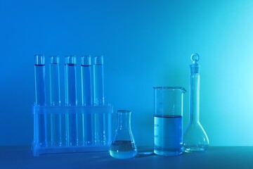 Laboratory analysis. Different glassware on table against blue background