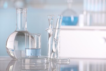 Laboratory analysis. Different glassware with liquid on white table indoors, space for text