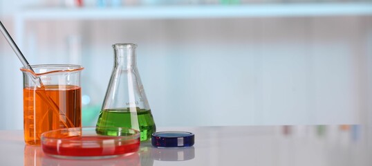 Laboratory analysis. Different glassware with liquids on white table against blurred background. Space for text