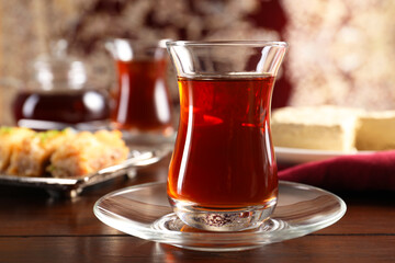Traditional Turkish tea in glass on wooden table, closeup