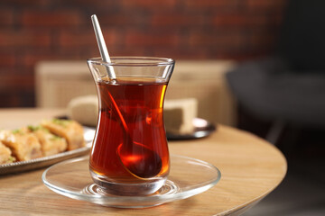 Traditional Turkish tea in glass on wooden table. Space for text
