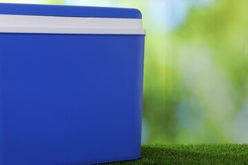 One plastic cool box on artificial grass, closeup. Space for text