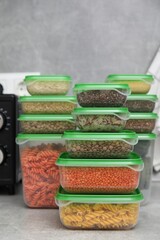 Plastic containers filled with food products on grey table in kitchen