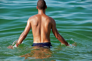 Geneva, Switzerland, Europe - single man ready to swim in waters of Lake Geneva, Paquis beach, summer
