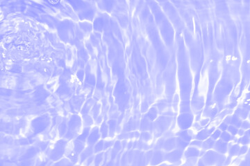 Water surface. Purple water waves on the surface ripples blurred. Defocus blurred transparent blue colored clear calm water surface texture with splash and bubbles. Water waves with shining pattern.