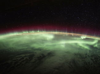 View of the Aurora Borealis (Northern Lights) as seen from a satellite in outer space, black night...
