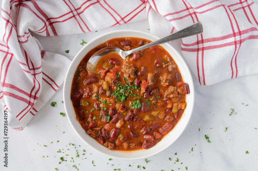 Wall mural Low fat bean soup or bean stew mexican style with kidneybeans, lean ground beef, and vegetables on plate isolated on light background. - Wall murals