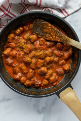 Fried sausage or bratwurst with spicy tomato curry sauce in a frying pan