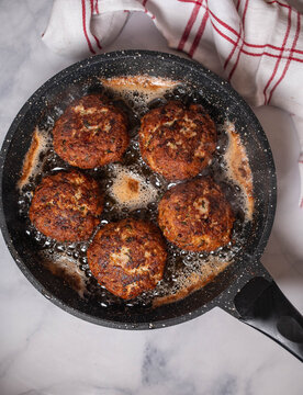 German meatballs or frikadellen frying in a frying pan