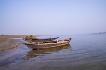 Naklejka na ściany i meble landscape view of Some wooden fishing boats on the shore of the Padma river in Bangladesh