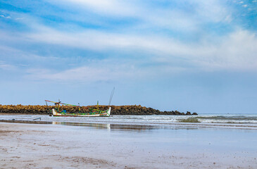 View of a clear sky with traditional fishing boats floating on the coast of Sumenep, Madura island, Indonesia.