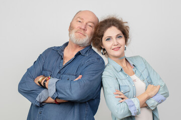 An adult daughter with an elderly father in denim clothes posing and looking at the camera....