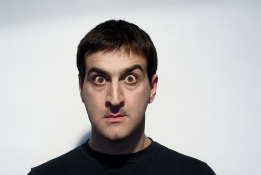 Adult man grimacing with his face and gesturing with his hands