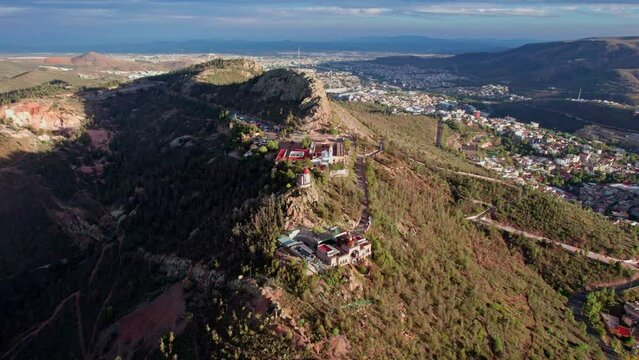 Dron footage of Zacatecas' Cerro de la Bufa, showcasing a majestic half orbit around the mountain and its iconic cable car area