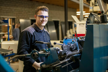 Portrait of a Young mechanical engineer working on steel machinery in a factory