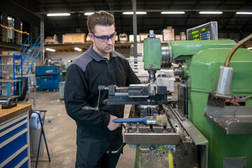 Young mechanical engineer working on steel machinery in a factory