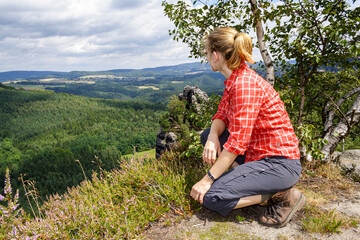 Frau sitzt auf Felsen und schaut in die Ferne, Elbsandsteingebirge, Sachsen, Deutschland