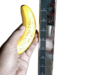ripe yellow banana measured by measurement tape, comparable to man penis size as short, small...