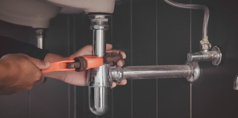 plumber at work in a bathroom, plumbing repair service , fix water plumbing leaks, replace the kitchen sink drain