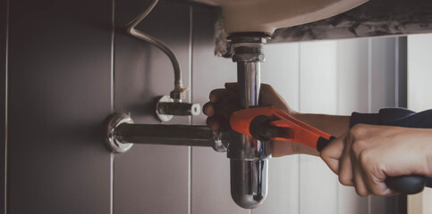 plumber at work in a bathroom, plumbing repair service , fix water plumbing leaks, replace the...