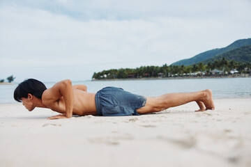 Muscular Asian athlete running on the sandy beach at sunset, experiencing the freedom and joy of an active lifestyle.