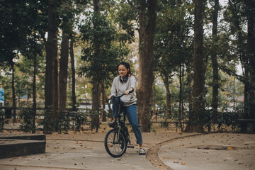 Fototapeta na wymiar Happy Asian young woman walk and ride bicycle in park, street city her smiling using bike of transportation, ECO friendly, People lifestyle concept.