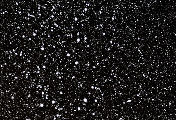 黒い背景に降雪。冬のイメージ背景。