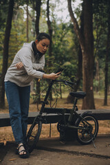 Obraz premium Happy Asian young woman walk and ride bicycle in park, street city her smiling using bike of transportation, ECO friendly, People lifestyle concept.