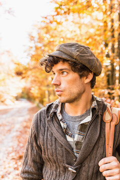 young man walking through warm glowing forest in the fall. Starnberg, Germany