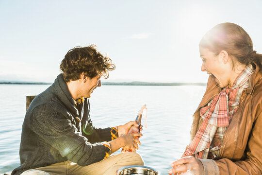 Man proposing to a woman at a romantic location on a lake. Starnberg, Germany
