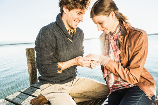 Man proposing to a woman at a romantic location on a lake. Starnberg, Germany